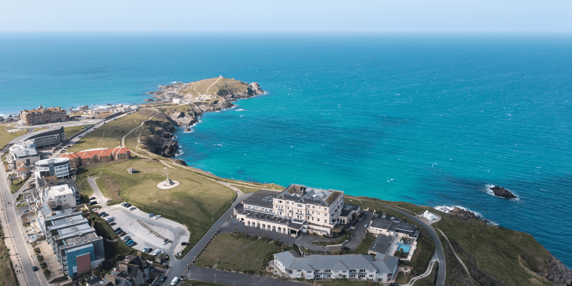 Hotel along a beach front surrounded by vast waters and other buildings - birds eye view