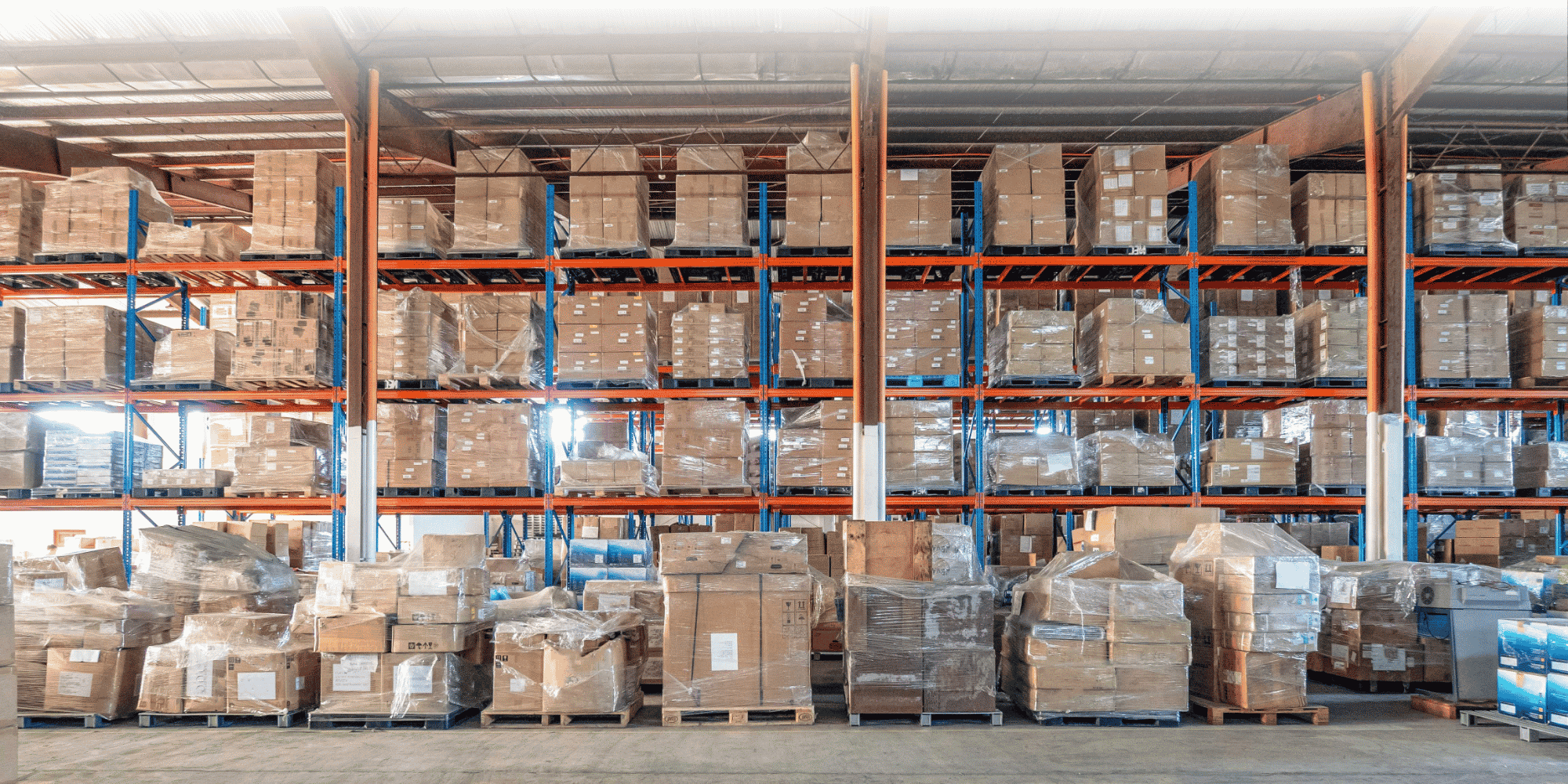 Plastic-wrapped box pallets stacked on warehouse racks, ready for shipping.