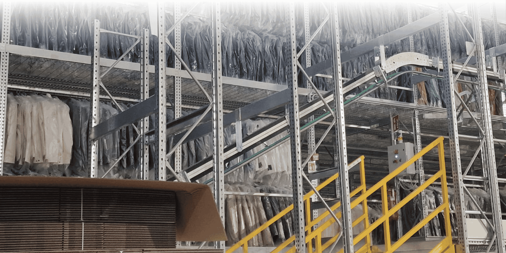Warehouse with clothing on long racks and metal pipes