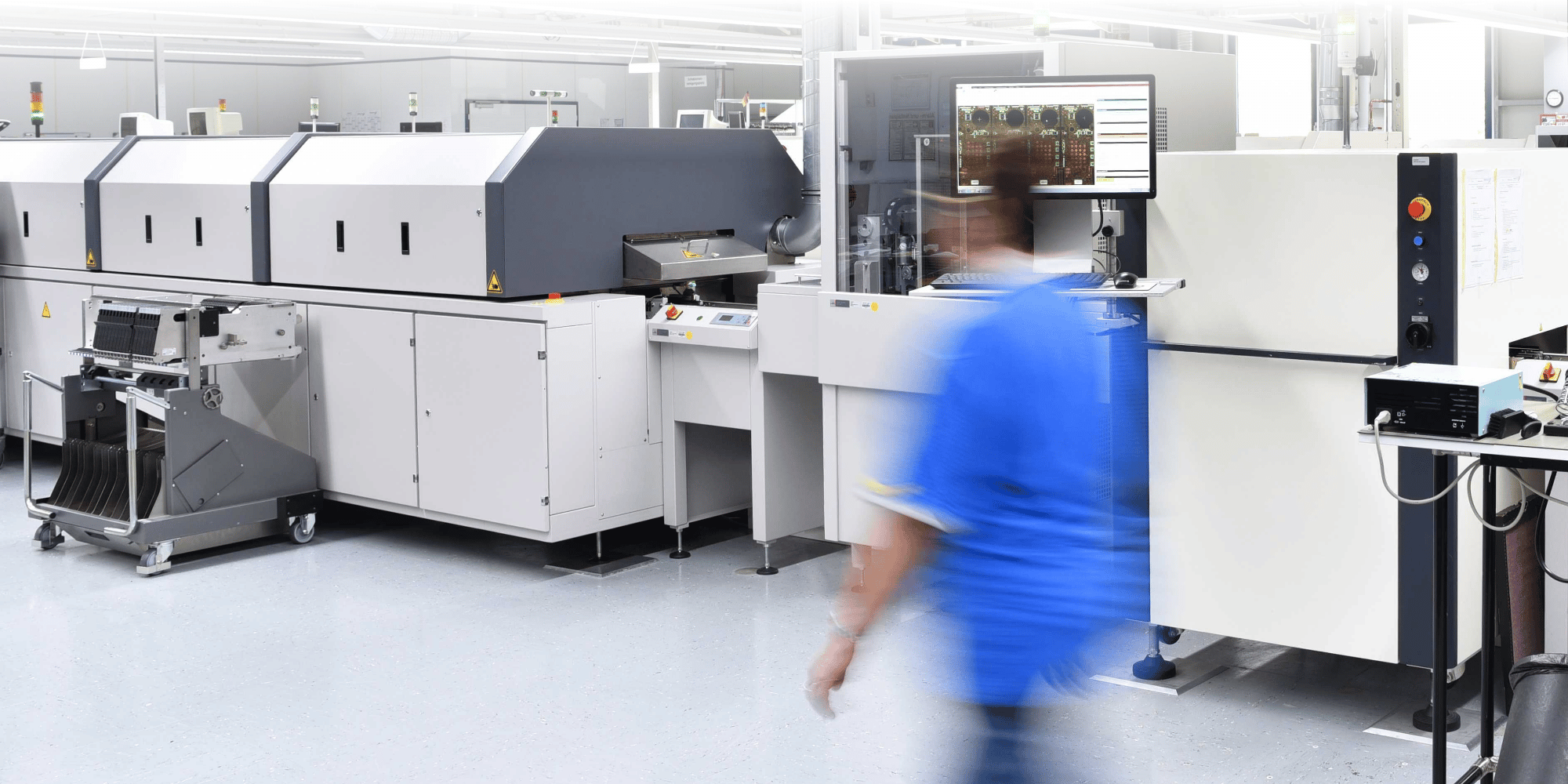 Large scale printing press with person blurred walking in frame