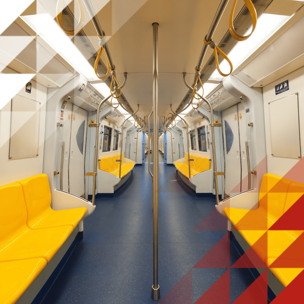 Empty metro carriage with yellow seats, grab handles, central pole and blue floor, viewed symmetrically towards the end doors.