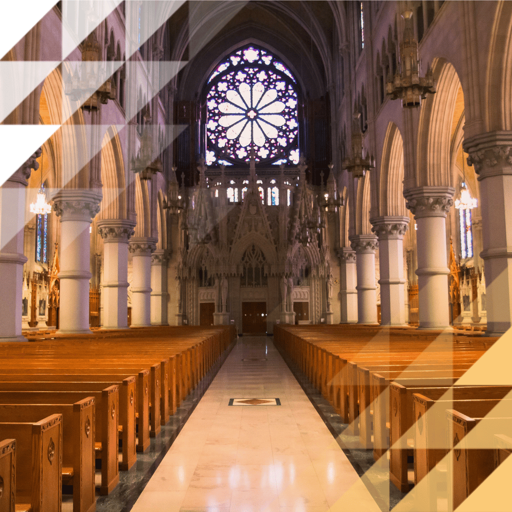 Gothic cathedral interior with rows of wooden pews, soaring stone columns, arched ceilings, and a large rose window with stained glass.