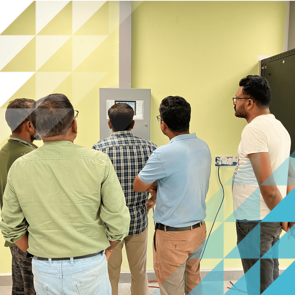 Smartly dressed men looking around a fire panel