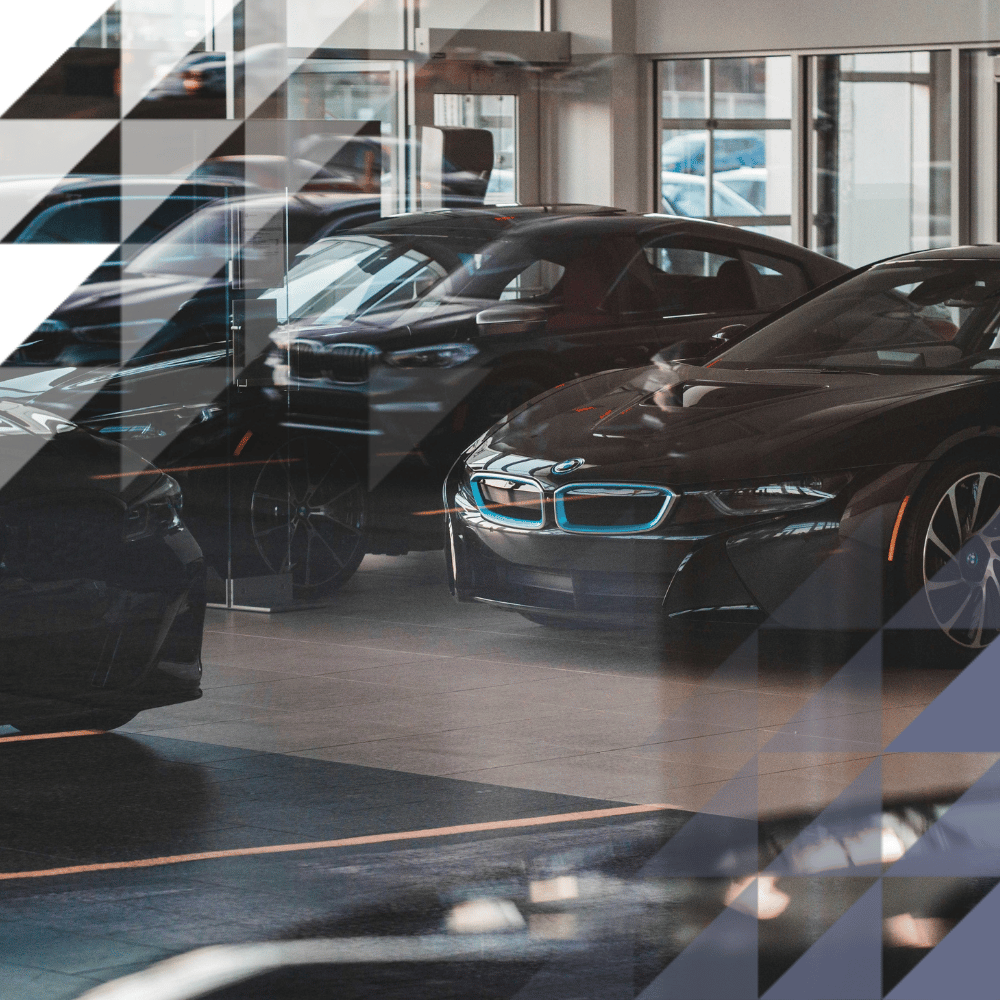 row of vechiles inside a dealership with a glass facade