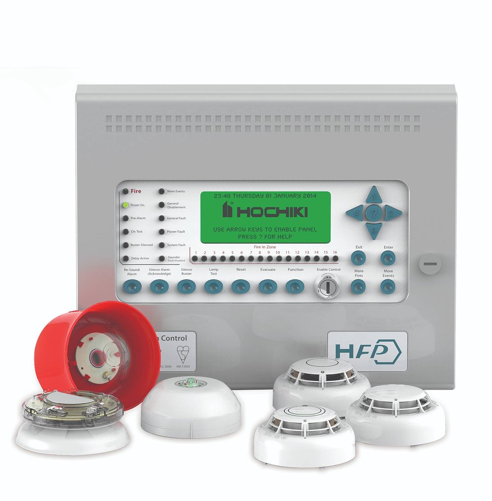 The Hochiki HFP fire alarm control panel with a selection of compatible devices, including smoke detectors, a call point, a sounder beacon and a red wall-mounted sounder. The panel features a green backlit LCD display and multiple control buttons and status indicators.