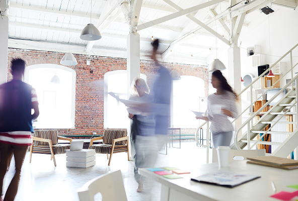 People holding documents walking in an office with motion blur